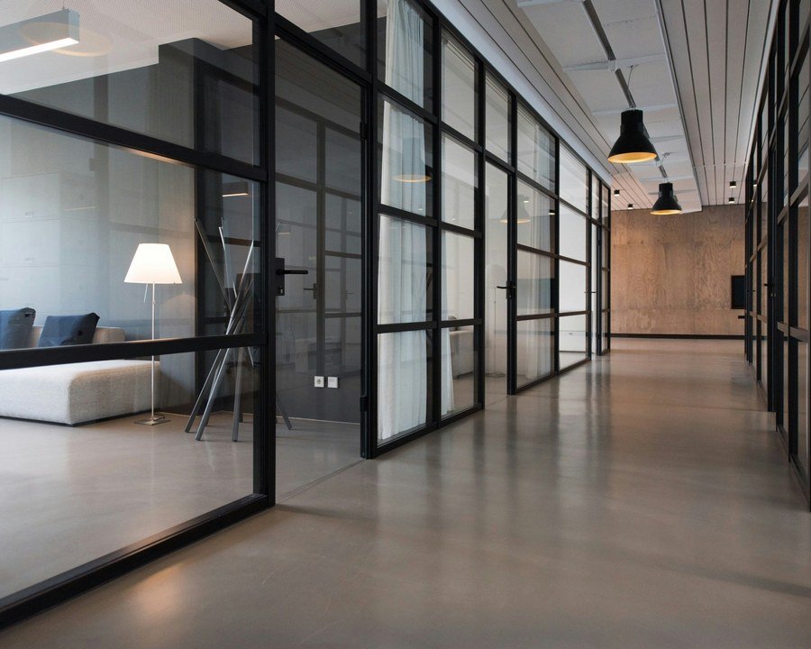 Oficina corporativa con divisiones de vidrio, referencia de remodelación de oficinas